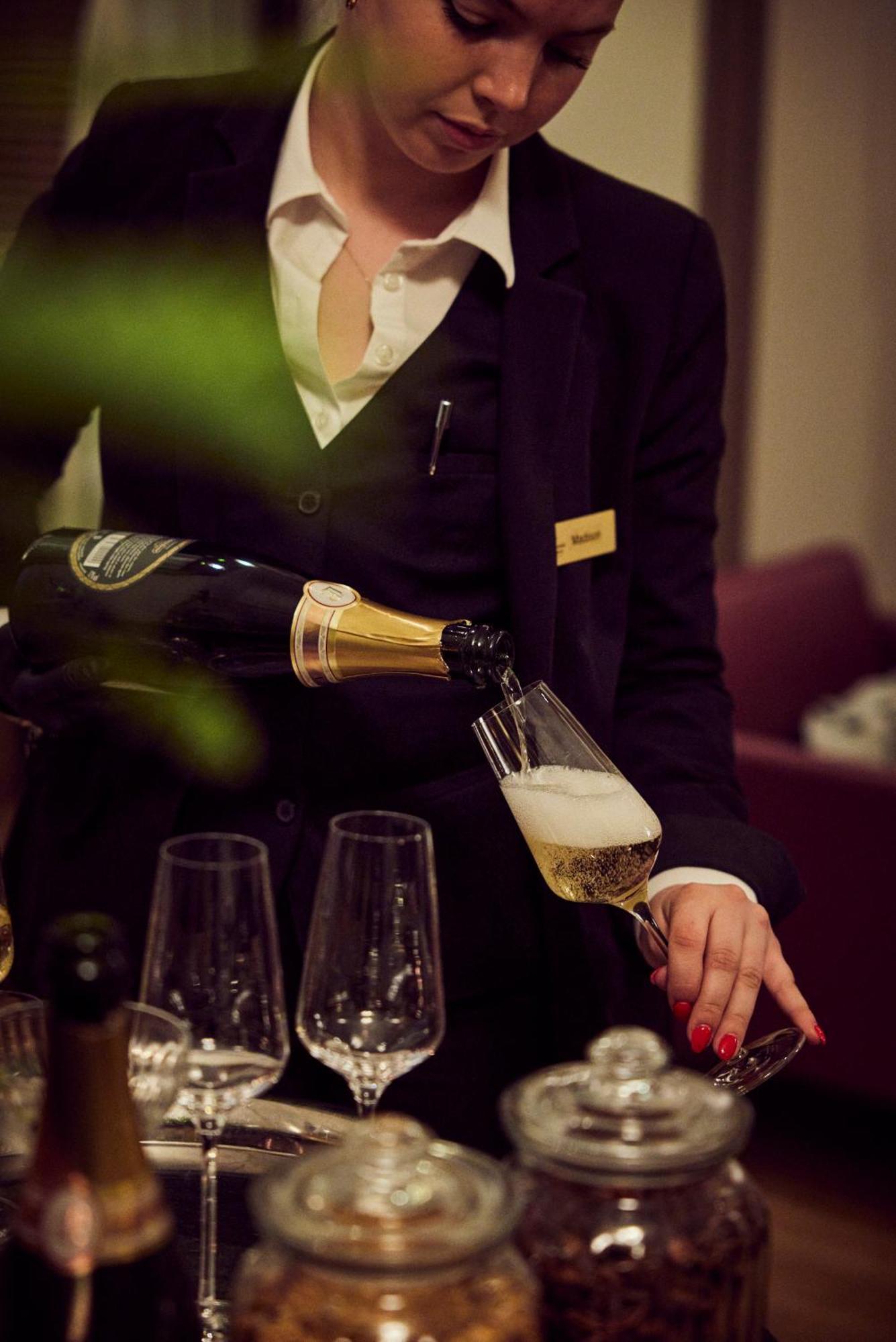 Lausanne Palace Bagian luar foto A butler serving champagne
